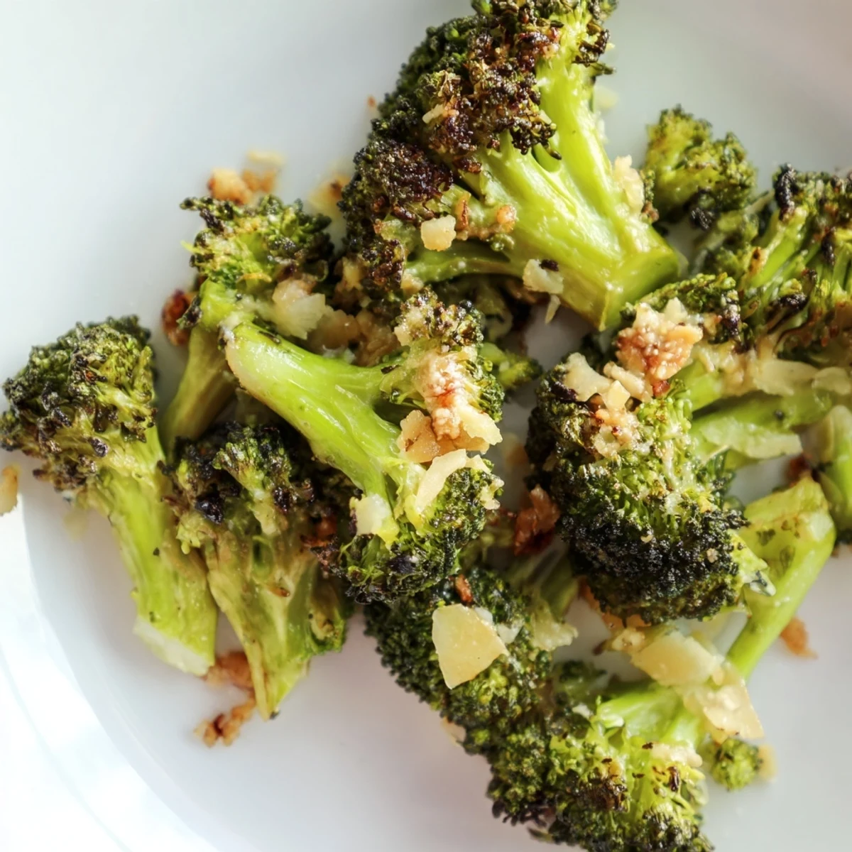 Crispy roasted broccoli with garlic and Parmesan on a sheet pan, golden edges and melted cheese glistening.  