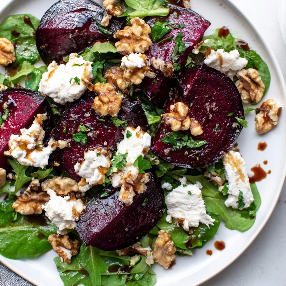 Close-up of Roasted Beet and Goat Cheese Salad with Walnuts, showcasing jewel-toned beets, chive garnish, and toasted nuts.