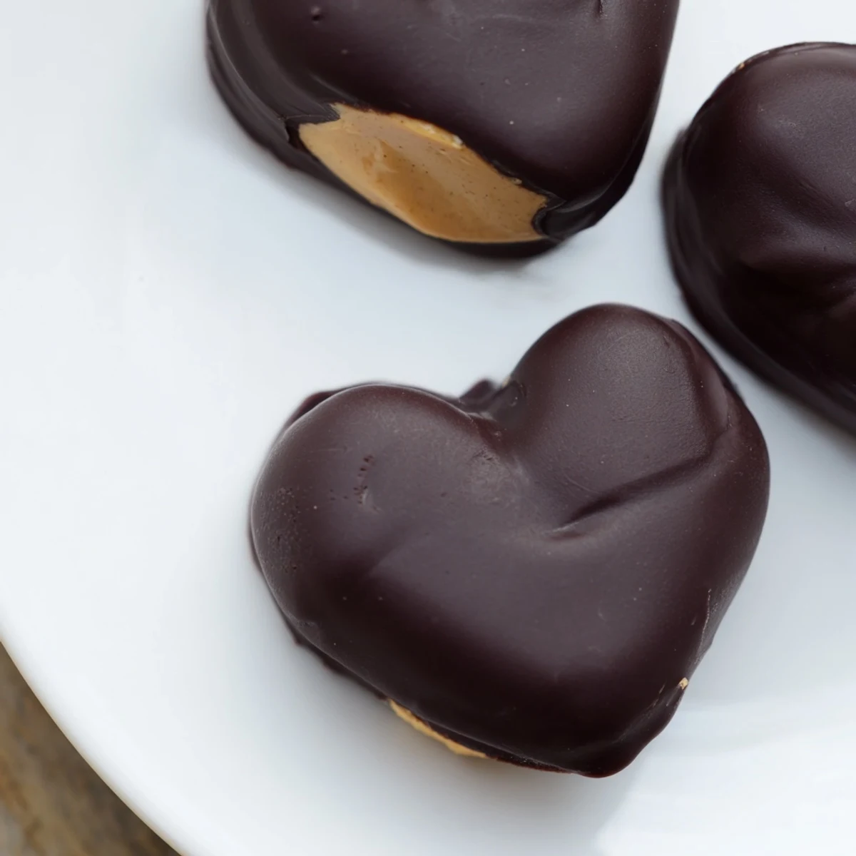 Sweet chocolate peanut butter hearts arranged on parchment paper, ready for Valentine's Day gifting or parties.