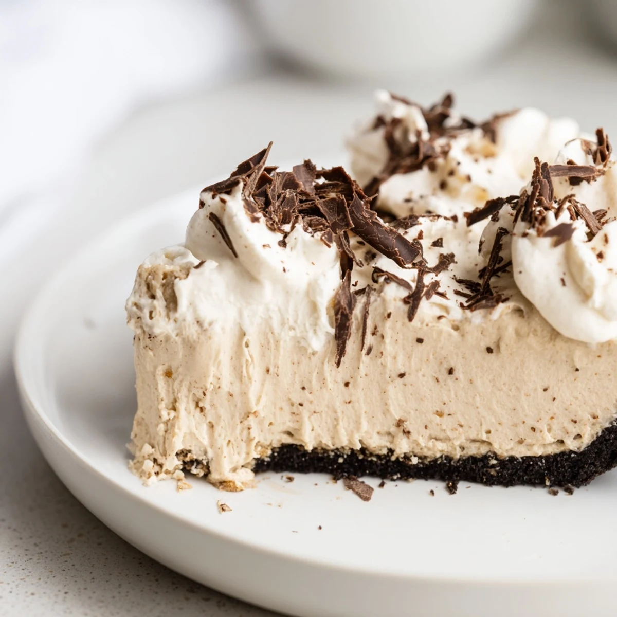 The finished Irish Cream Cheesecake, a creamy chocolate and coffee dessert garnished with shaved chocolate on a rustic plate.
