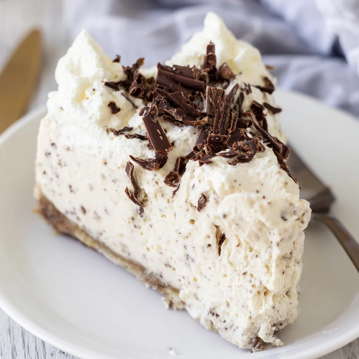 A chilled Irish Cream Cheesecake featuring a chocolate cookie crust and a smooth, non-alcoholic Irish cream flavor.