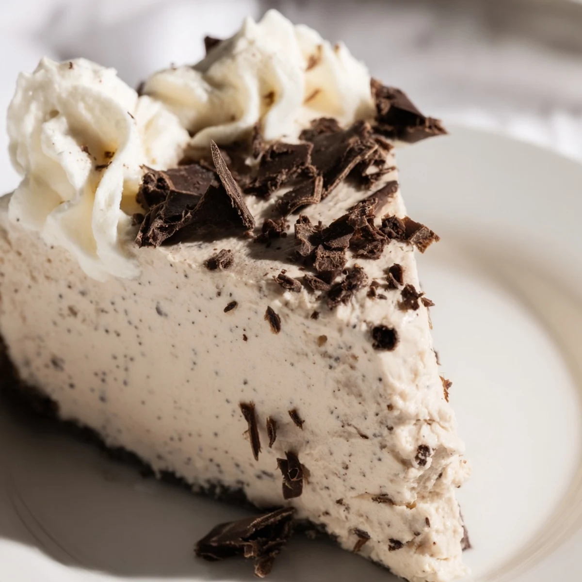 A slice of Irish Cream Cheesecake with a dense, velvety texture and whipped cream topping, ready to serve.
