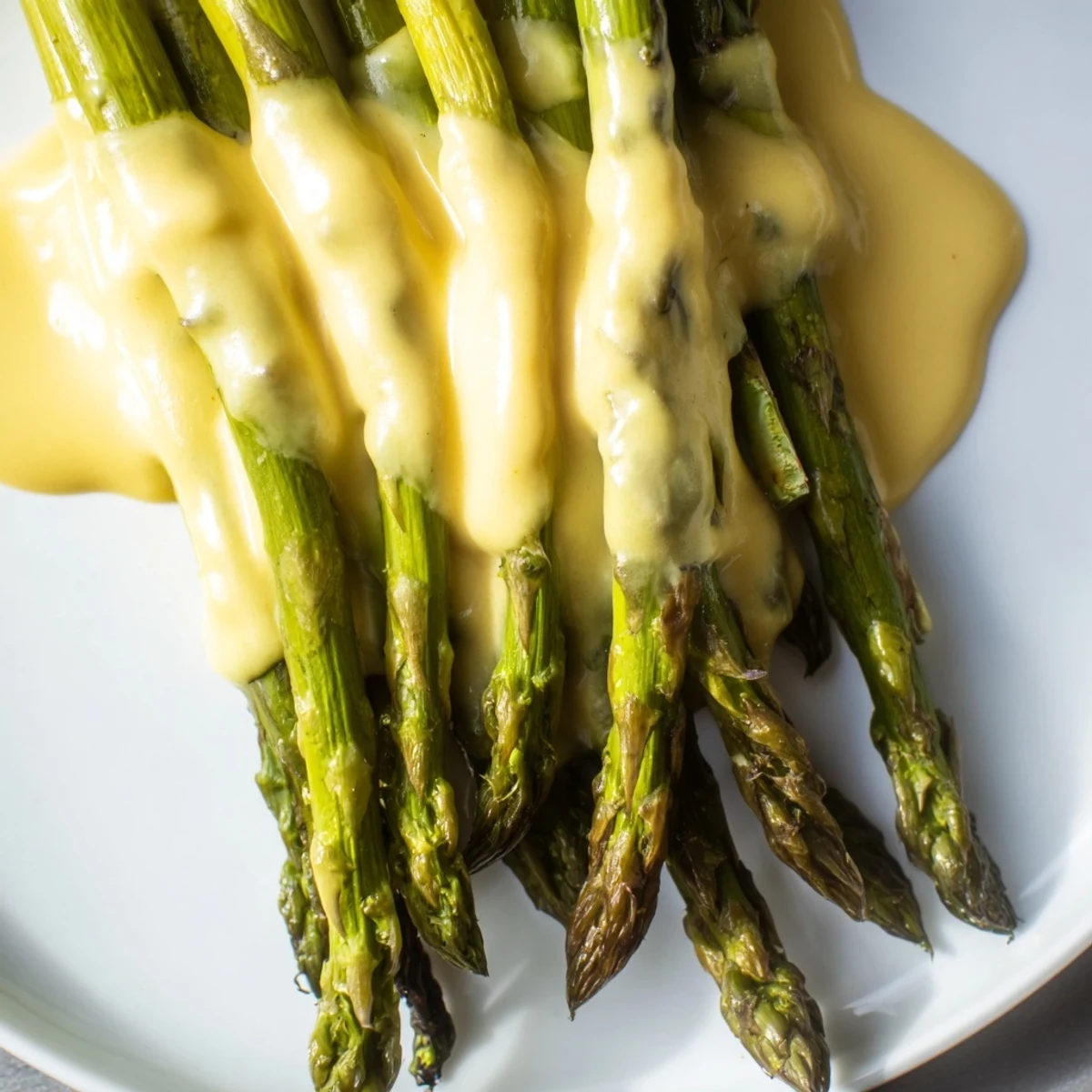 Tender roasted asparagus spears drizzled with a warm, velvety Roasted Asparagus with Hollandaise Sauce for an elegant spring side.
