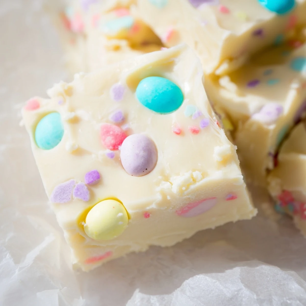 A close-up of homemade Easter Fudge with chopped chocolate eggs and buttery white chocolate.  