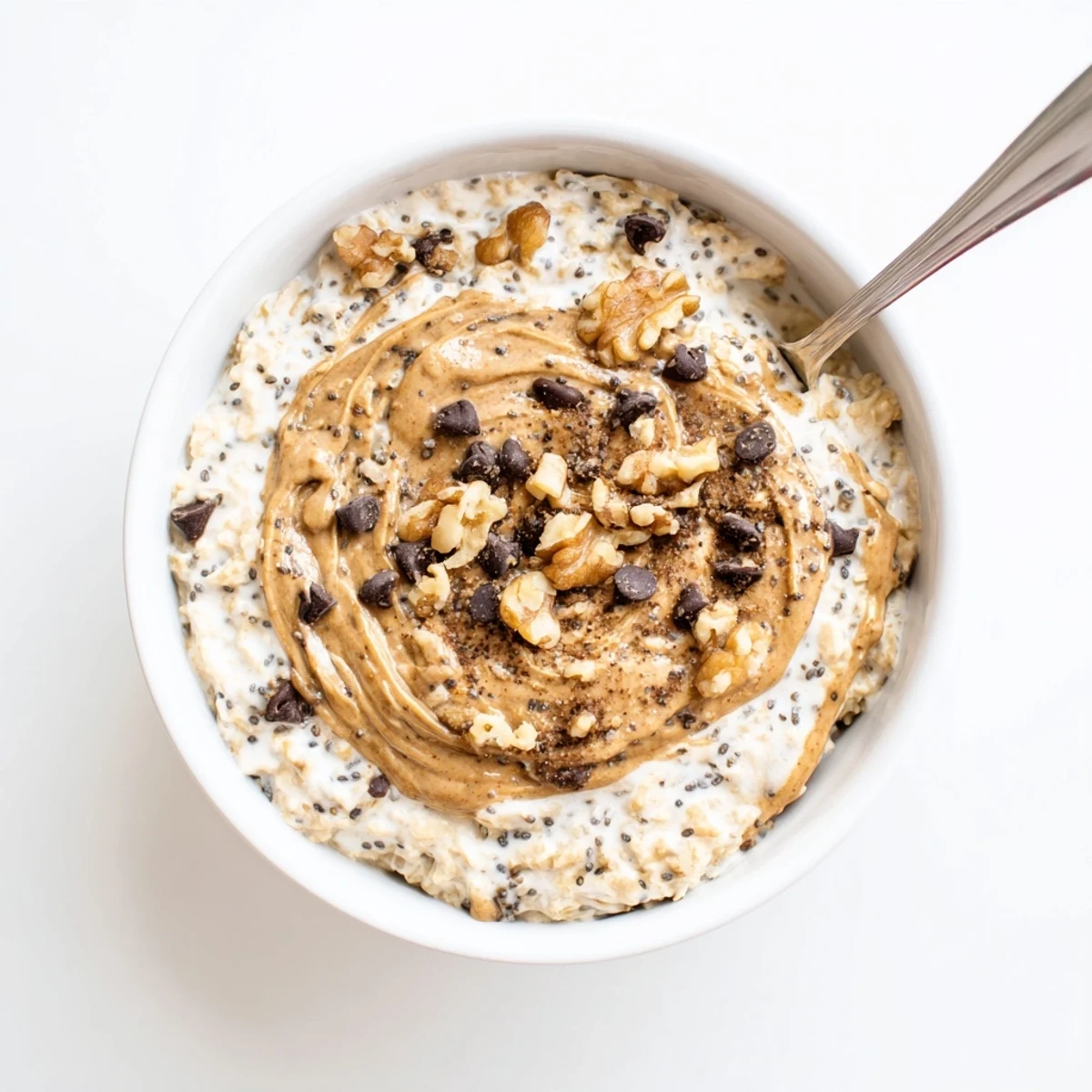 A creamy bowl of Cookie Dough Overnight Oats with chocolate chips and almond butter, served chilled in a jar.