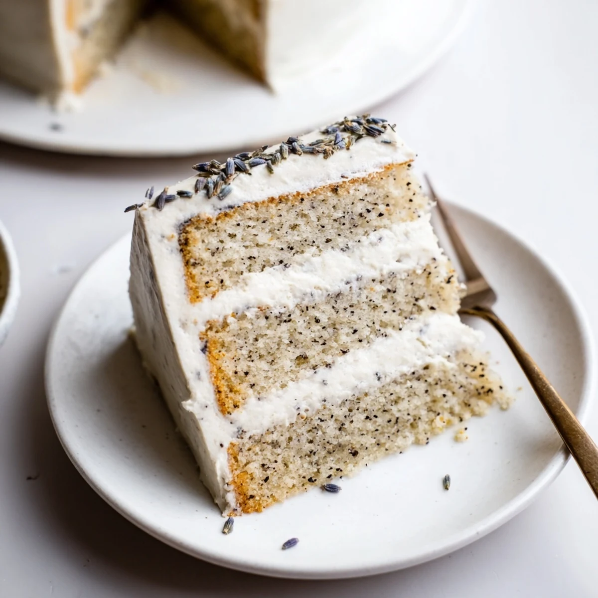 Moist Earl Grey cake layers with lavender syrup and creamy vanilla frosting, sliced beautifully for a dessert plate.