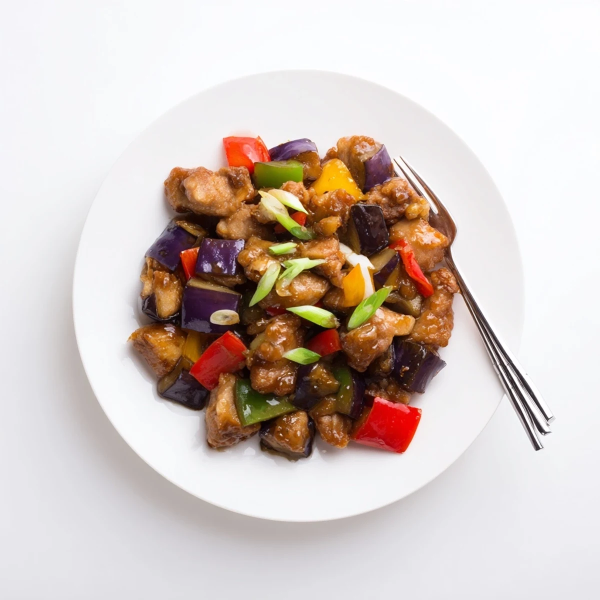 Close-up of Black Vinegar Chicken with Bell Peppers and Eggplant in a hot skillet, showcasing tender meat and glossy, tangy sauce.