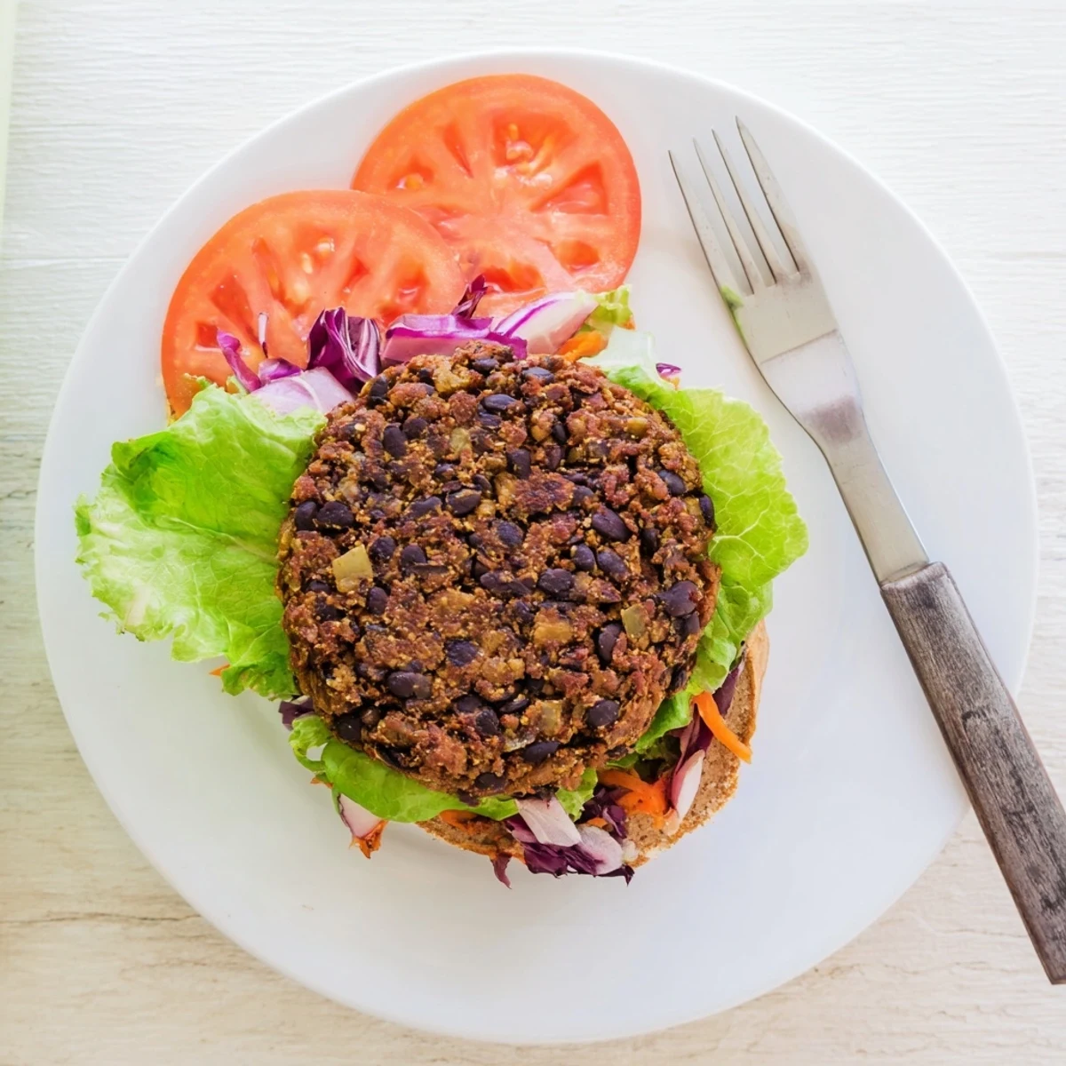 A close-up of a homemade Mushroom Veggie Burger patty showing hearty mushroom and bean texture.