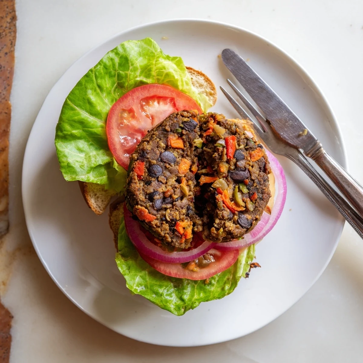 Stacked Mushroom Veggie Burgers with melted cheese and pickles on a rustic wooden cutting board.