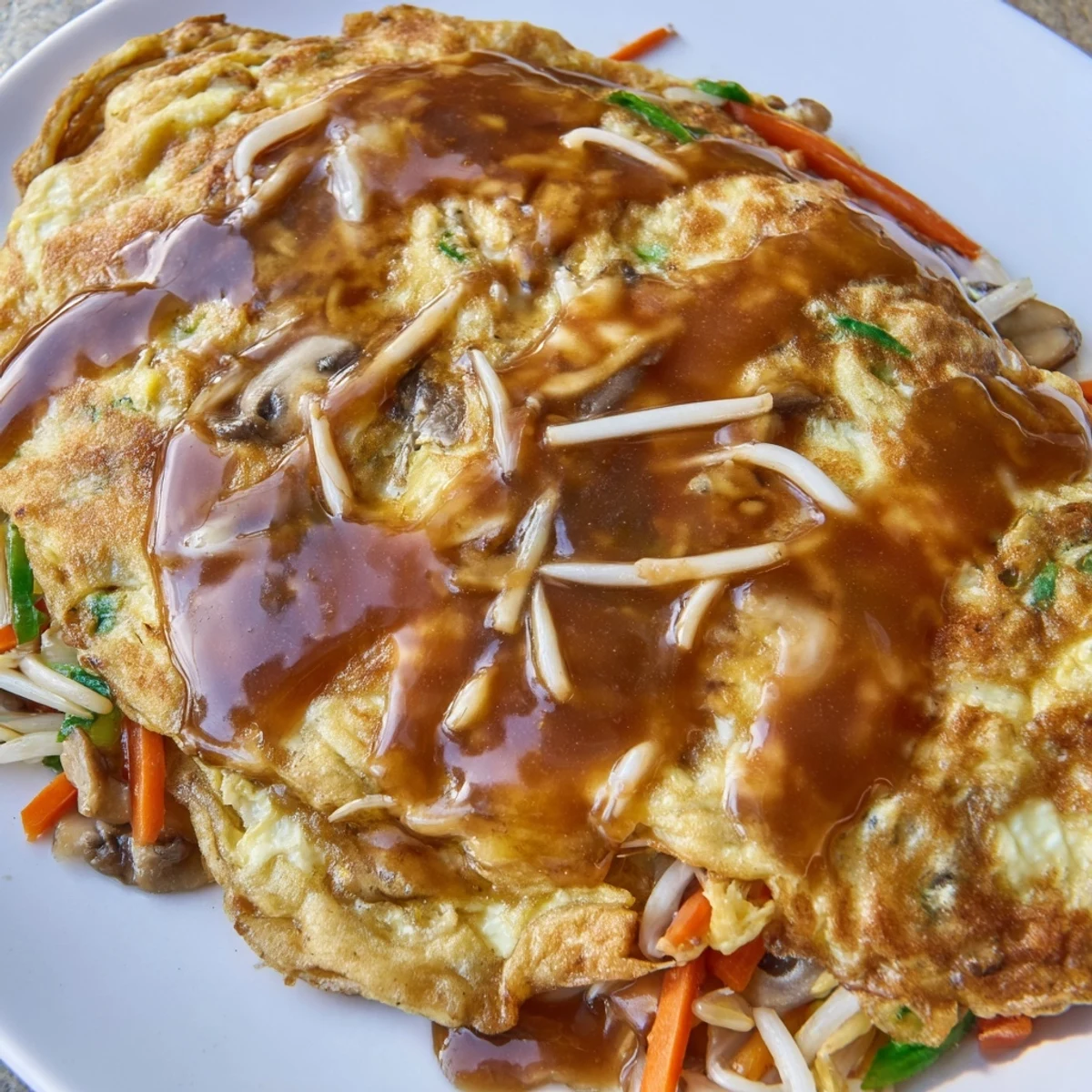 Golden crispy Egg Foo Young patties drizzled with rich savory brown gravy