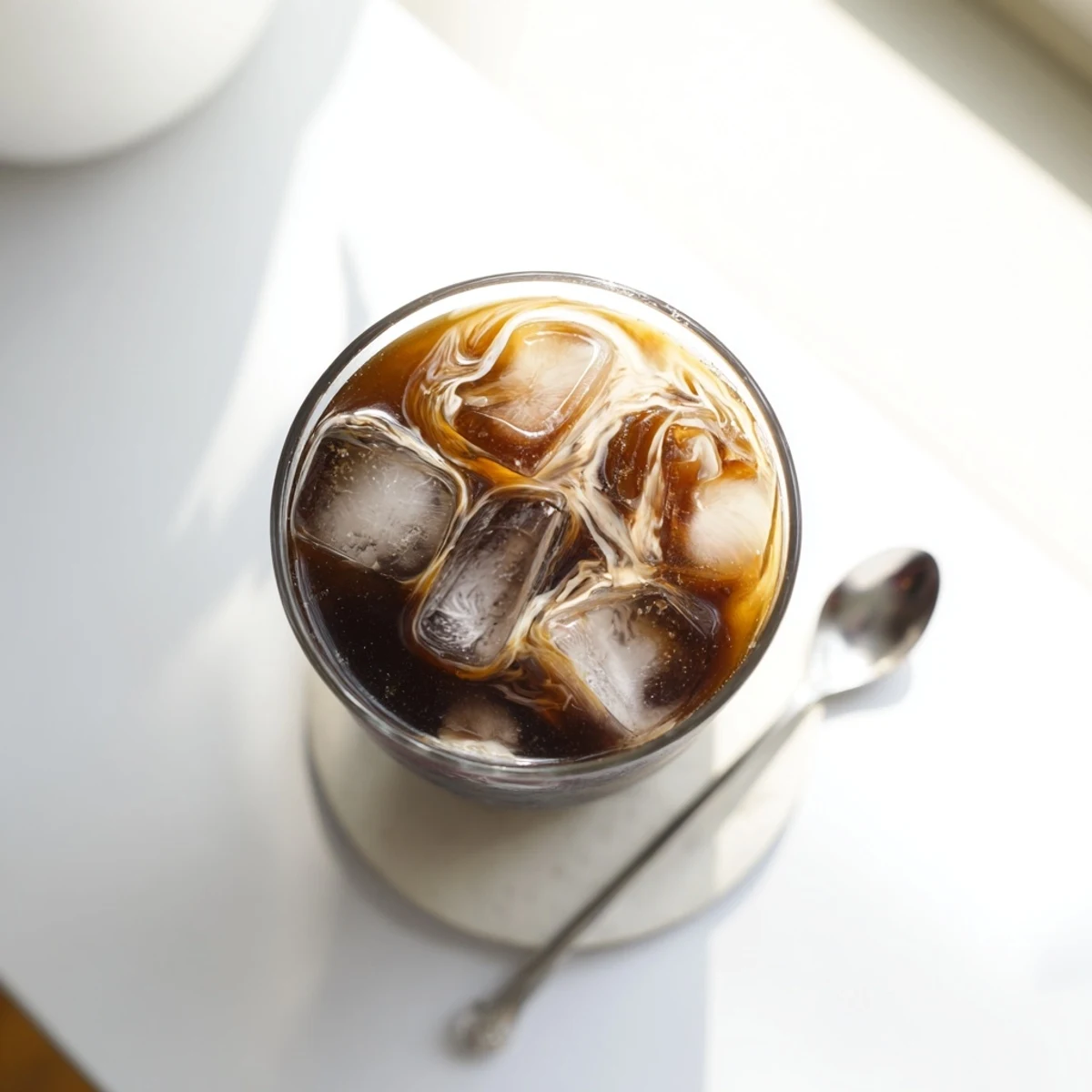 Refreshing iced coffee with milk poured over ice in a tall glass