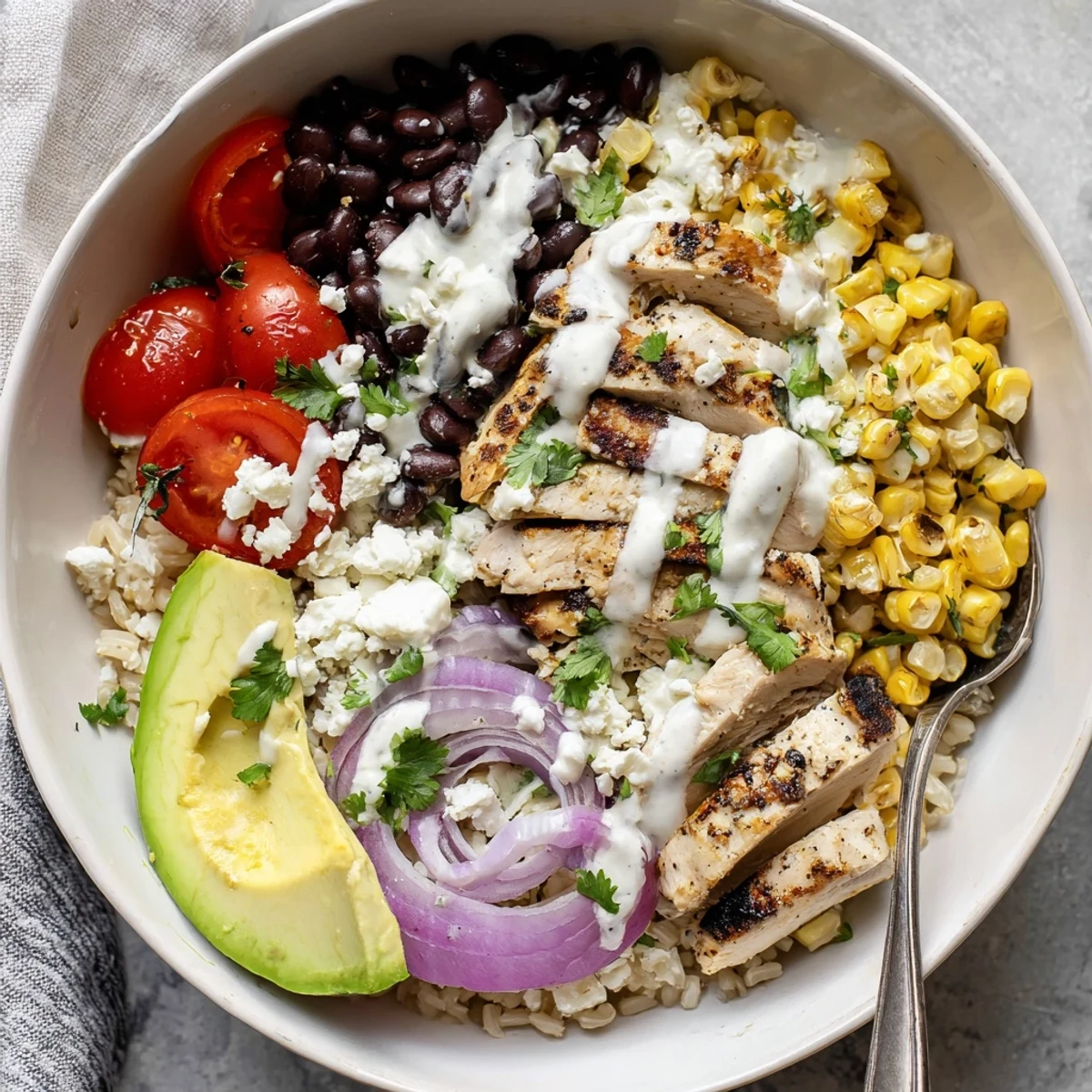 Hearty protein packed street corn chicken bowl arranged with seasoned chicken, cotija cheese, cherry tomatoes, and cilantro garnish in a colorful serving dish