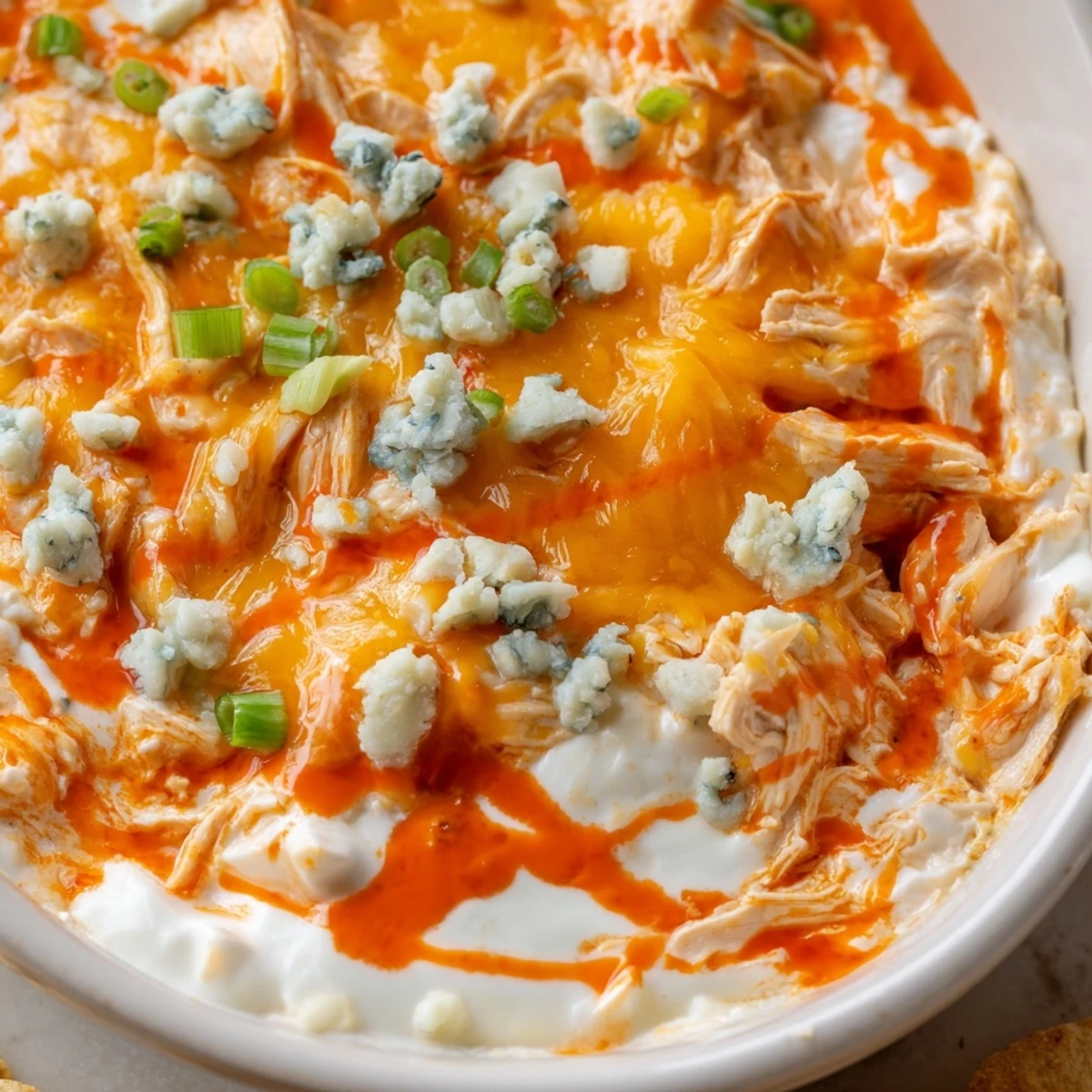 Creamy Crockpot Buffalo Chicken Dip bubbling with melted cheddar and mozzarella cheese
