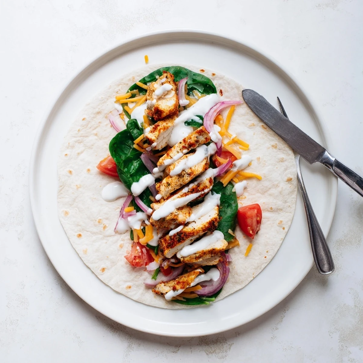 Golden low carb cheesy garlic chicken wraps sliced open revealing melted cheese and fresh vegetables inside