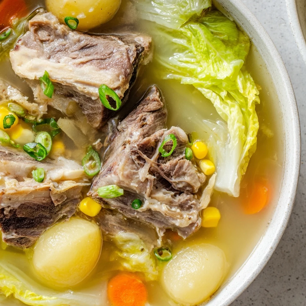 Hearty bowl of Filipino Bulalo featuring fall-apart beef shank and marrow in rich golden soup