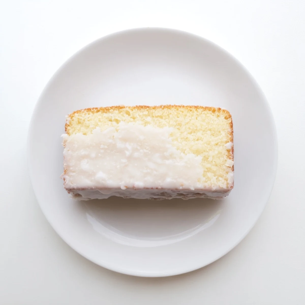 Golden church cake with vanilla glaze drizzled over a moist tender sponge ready to slice