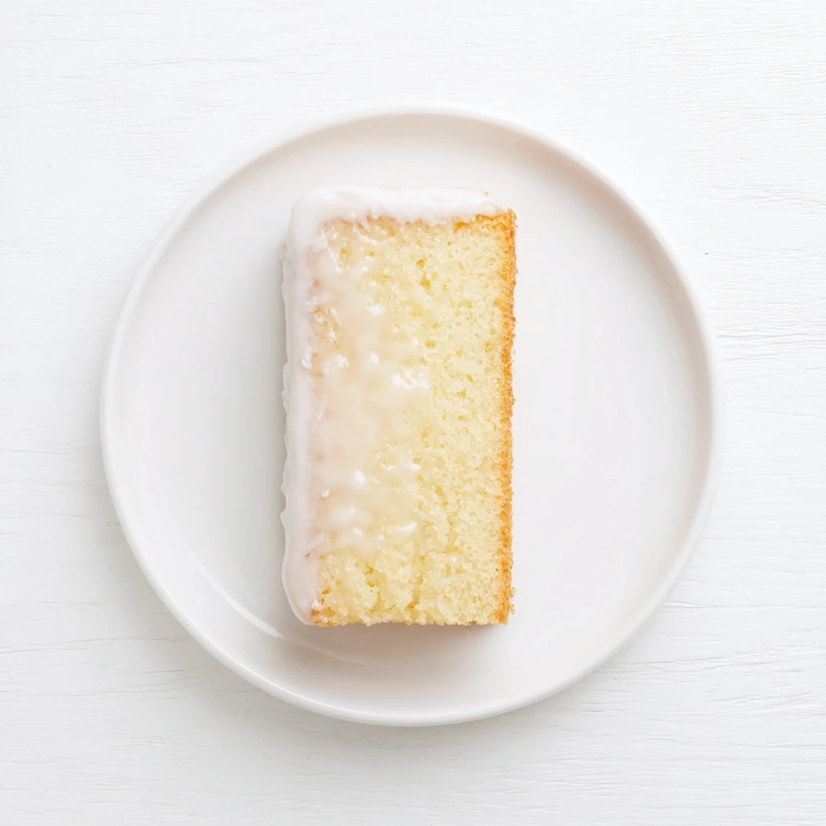 Classic church cake sliced on a white platter with sweet powdered sugar glaze dripping