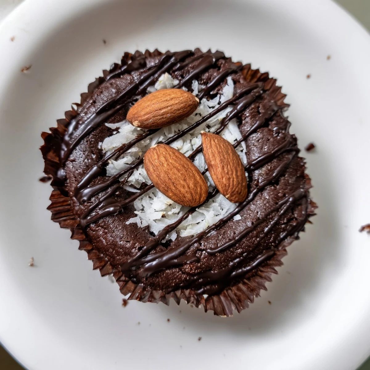 Rich flourless almond joy cupcakes drizzled with melted chocolate and topped with roasted almonds