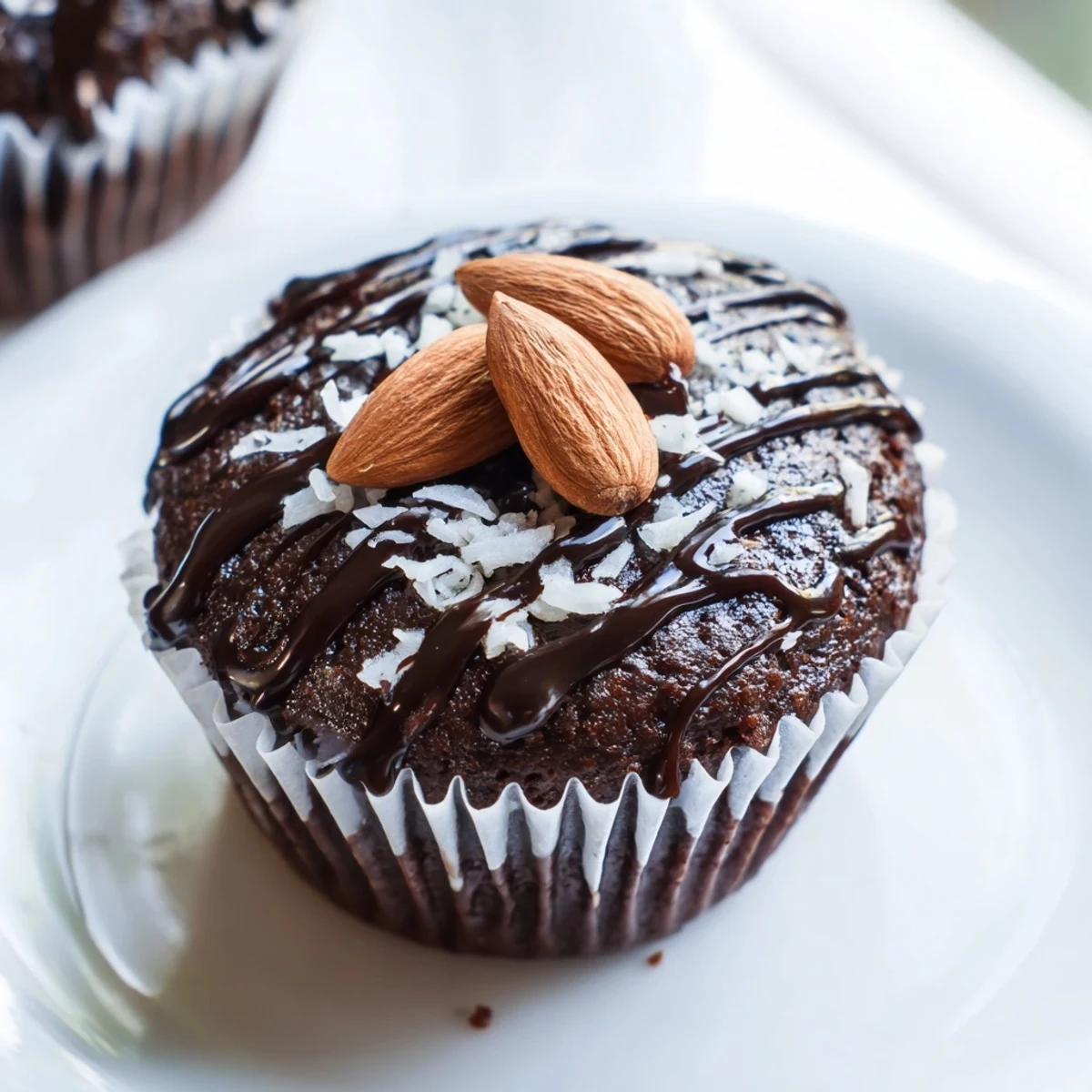 Decadent flourless almond joy cupcakes featuring dark chocolate ganache coconut filling and crunchy almond garnish