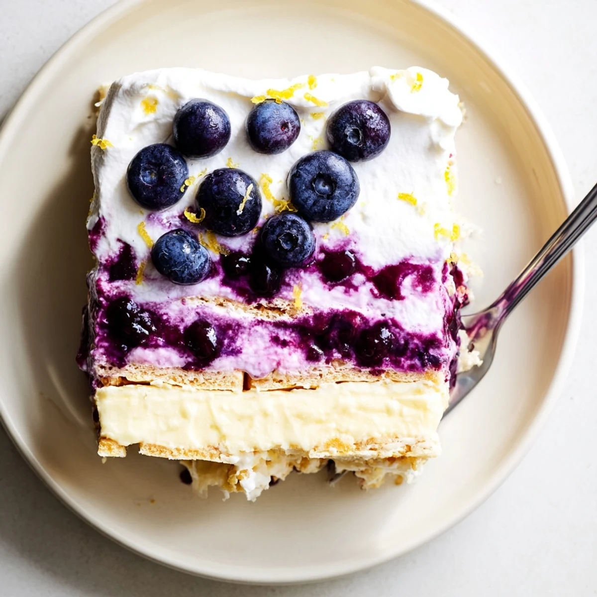 Thick slices of lemon blueberry lasagna showing purple berry swirls and creamy layers