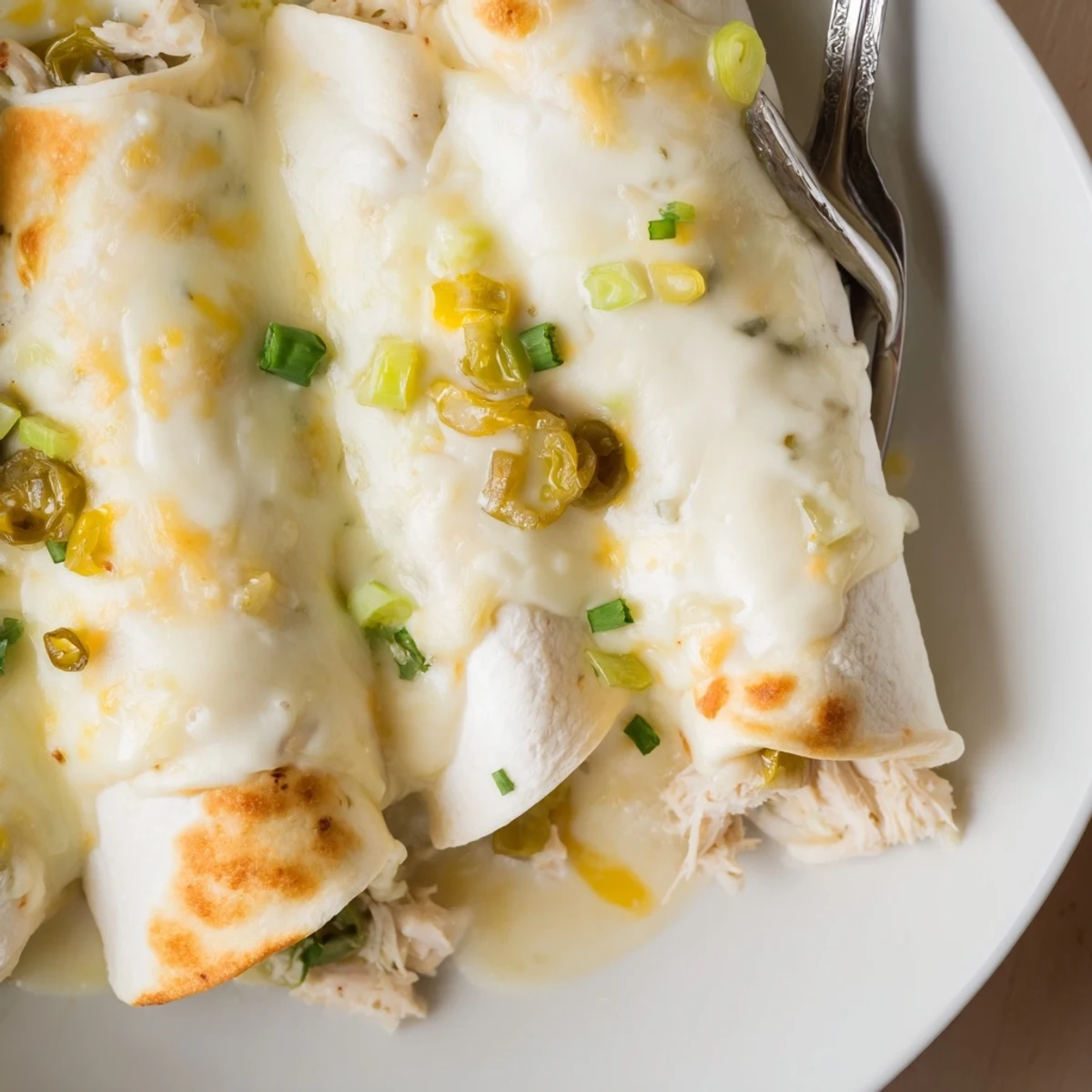 Family-style Creamy White Chicken Enchiladas served with Spanish rice and fresh lime.