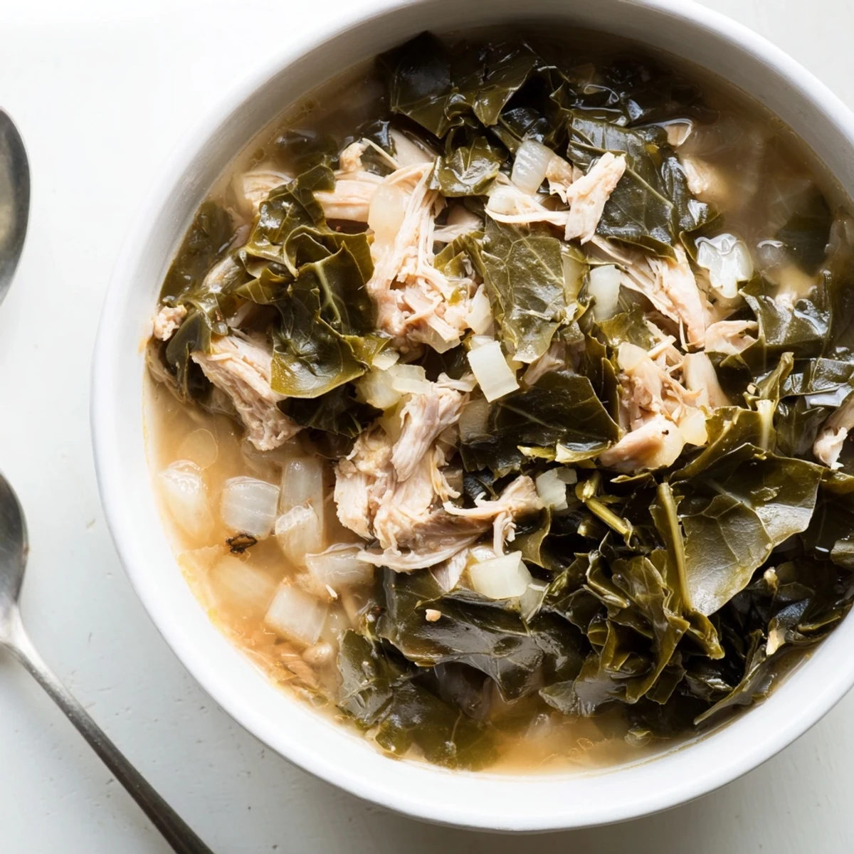 Vibrant green collard greens simmered in savory chicken broth with onions and garlic