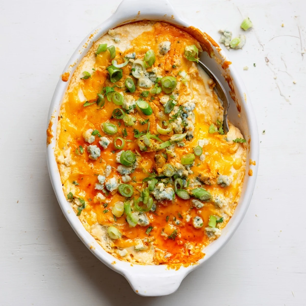 Rustic white bean buffalo dip with spicy sauce served warm with tortilla chips and celery