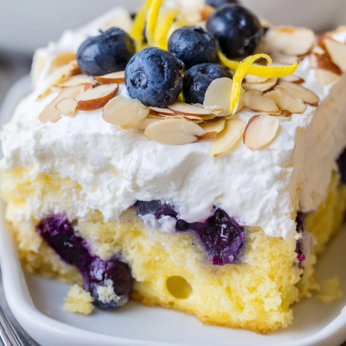 Moist lemon poke cake studded with blueberries and drizzled with tangy lemon syrup