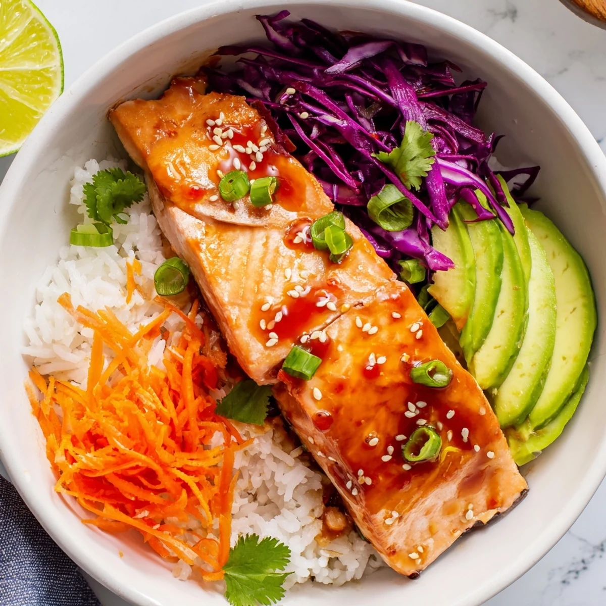 Tender caramelized sriracha honey glazed salmon bowls drizzled with sauce and lime